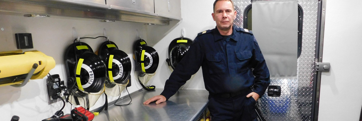 An RCMP officer stands inside an equipment truck beside personal protective equipment. 