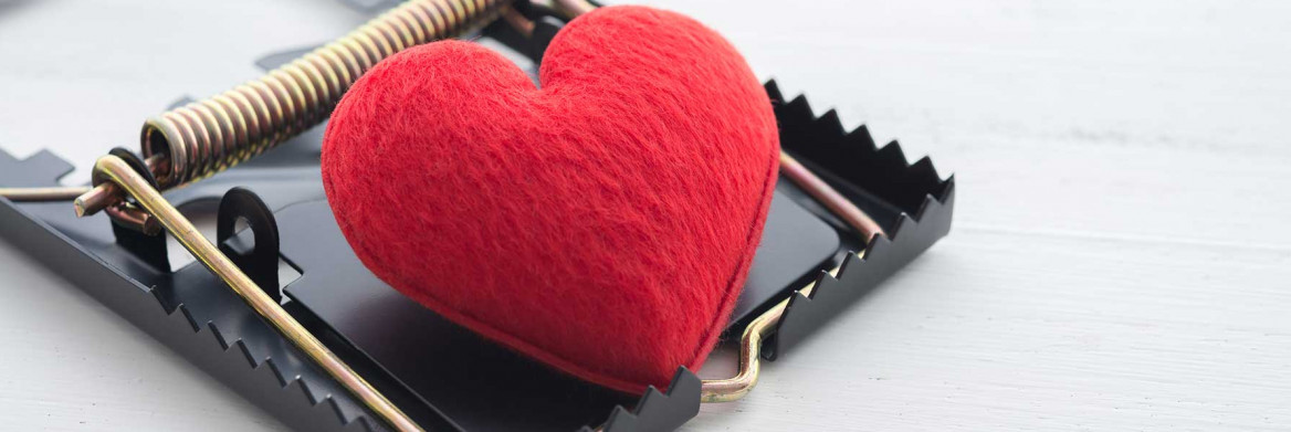 A small, red heart-shaped cushion in a mouse trap.
